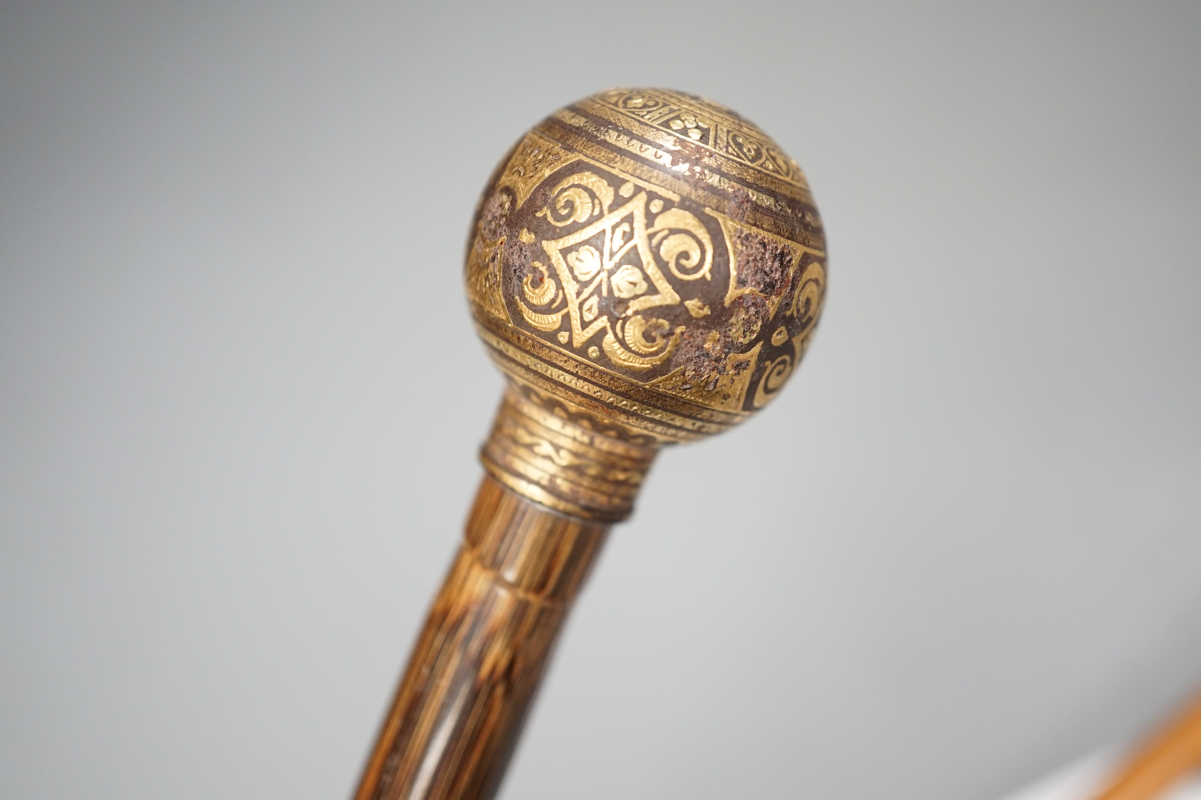 An early 20th century ivory ‘sphinx’ parasol handle, 84cm, together with another gold and iron damascened parasol handle, 62cm